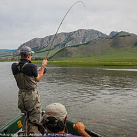 Buy canvas prints of A fisherman with a Taimen Trout on the end of his line in Mongolia, Moron, Mongolia - July 14th 2014 by SnapT Photography