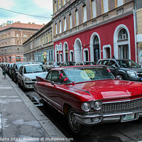 Buy canvas prints of Vintage red cadillac deville car parked in a Budapest street in the evening by SnapT Photography