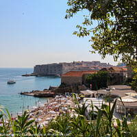 Buy canvas prints of A crowded Plaza Banje Beach in Dubrovnik, with the old town in the background by SnapT Photography