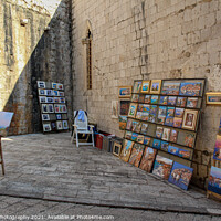 Buy canvas prints of An artists stall in Dubrovnik's old town in a late summers afternoon, Croatia by SnapT Photography