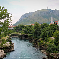 Buy canvas prints of The Neretva River flowing through Mostar, with Hum Hill and Christain Cross by SnapT Photography