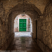 Buy canvas prints of An alleyway in the old town of Kotor, Montenegro, with a green door at the end by SnapT Photography