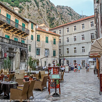 Buy canvas prints of A cafe in a square at sunset, in the Old town of Kotor, Montenegro by SnapT Photography