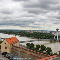 Buy canvas prints of A view across the River Danube, Most SNP Bridge, and Ovsiste, Bratislava by SnapT Photography