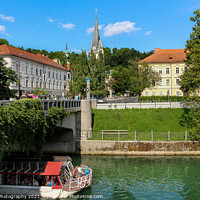 Buy canvas prints of A tourist boat passing under the St. James Bridge on the Ljublijanica River by SnapT Photography
