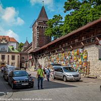 Buy canvas prints of Artists pictures displayed on the wall of St. Florian's Gate on Pijarska Street, old town of Krakow, Poland by SnapT Photography