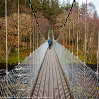 Buy canvas prints of Man walking over an old wooden suspension bridge across a river in Scotland by SnapT Photography