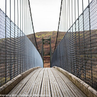 Buy canvas prints of View across a wooden suspension bridge in the Scottish highlands by SnapT Photography