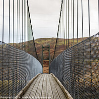 Buy canvas prints of View across a wooden suspension bridge in the Scottish highlands by SnapT Photography
