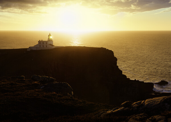 A hazy sunset over Stoer Lighthouse Picture Board by Anthony McGeever