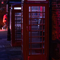 Buy canvas prints of Red English Telephone boxes in a night time street by That Foto