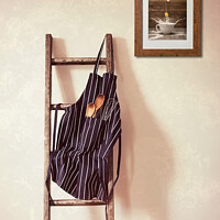 Buy canvas prints of Kitchen Apron Hanging On Ladder by Amanda Elwell