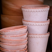 Buy canvas prints of Pile Of Terracotta Flower Pots On A Shelf by Peter Greenway