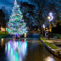 Buy canvas prints of The Christmas Tree In The River At Bourton-on-the-Water by Peter Greenway