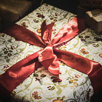 Buy canvas prints of Wrapped Christmas Present Tied Up In Red Ribbon by Peter Greenway