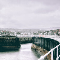 Buy canvas prints of The Harbour Lighthouse & Curved Pier At Whitby On A Cold Winters by Peter Greenway