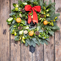 Buy canvas prints of Traditional English Christmas Wreath On A Wooden Farmhouse Door by Peter Greenway