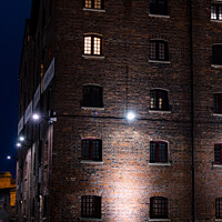 Buy canvas prints of Illuminated Victorian Red Brick Warehouse At The Historic Docks  by Peter Greenway