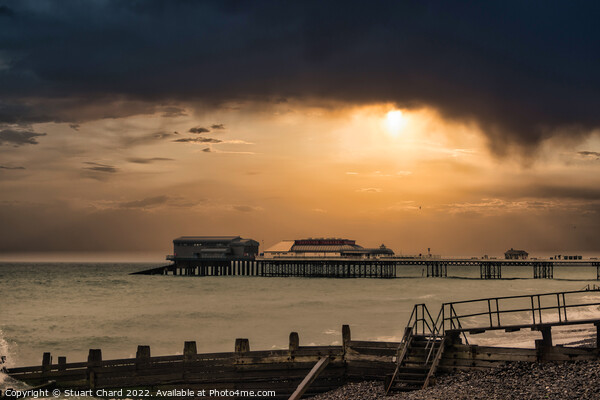 A sunset over Cromer pier in winter Picture Board by Stuart Chard