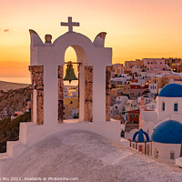 Buy canvas prints of Blue domed churches and bell tower facing Aegean Sea with warm sunset light in Oia, Santorini, Greece by Chun Ju Wu