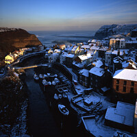 Buy canvas prints of Snow Covered Rooftops at Staithes by Mark Sunderland