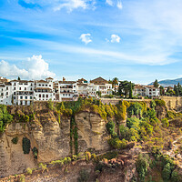 Buy canvas prints of Famous Ronda restaurants and colonial houses overlooking the scenic gorge and the Puente Nuevo bridge by Elijah Lovkoff