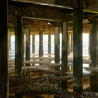 Buy canvas prints of Reflections under the pier by Geoff Taylor