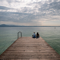 Buy canvas prints of Tourists Sitting on jetty on Lake Garda in Sirmione by Dietmar Rauscher