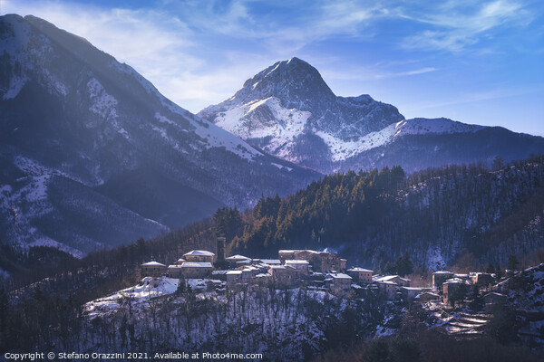 Snowy village and Apuan mountains in winter. Framed Mounted Print by Stefano Orazzini