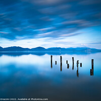 Buy canvas prints of Remains of a wooden jetty in a blue lake by Stefano Orazzini