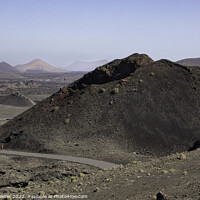 Buy canvas prints of Lone figure walking in the Timanfaya National Park by Keith Bowser