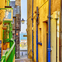 Buy canvas prints of Narrow Colourful Lane to the sea in Tenby Wales by John Gilham