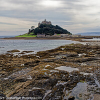 Buy canvas prints of St Michaels Mount Marazion Cornwall England UK seen from a rocky outcrop on the mainland beach by John Gilham