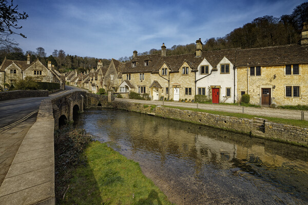 The bridge over the river in the picturesque village of Castle Combe in the Cotswolds Wiltshire UK Picture Board by John Gilham