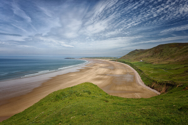A landscape view of the beach at Rhossili Bay on the Gower Peninsula in Wales UK Picture Board by John Gilham