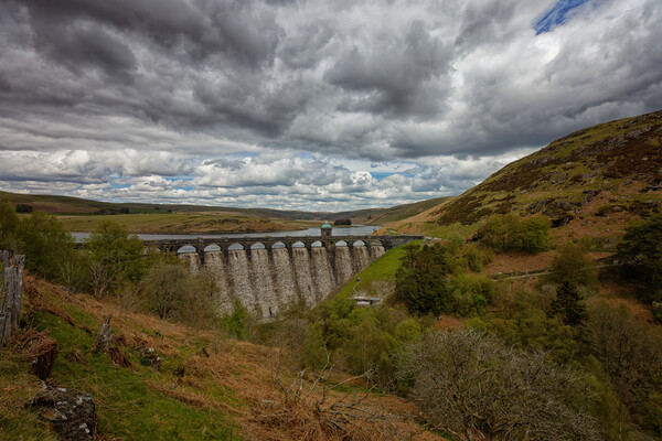 Cloudy Sky over a Dam Landscape of the Elan Valley Wales Picture Board by John Gilham