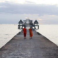 Buy canvas prints of Thai monks on the bridge or Pier , which leads to the never finished and abandoned Thai temple right on the Gulf in Thailand in the province of Chonburi by Wilfried Strang