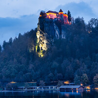 Buy canvas prints of Lit Up Castle Bled on Lake Bled during Blue Hour. by Maggie Bajada