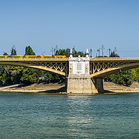 Buy canvas prints of Yellow bridge with tram crossing over Danube River, Budapest, Hungary. by Maggie Bajada