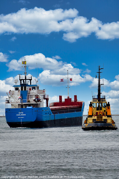 Coastal freighter escorted by tugboat Picture Board by Roger Mechan