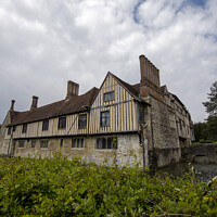 Buy canvas prints of Ightham Mote under a cloudy sky  by Fiona Etkin