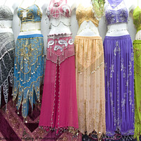 Buy canvas prints of Belly dancer's dresses for sale in the cloth souk, Bur Dubai, UAE by Gordon Dixon
