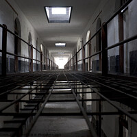 Buy canvas prints of Light at the end of a corridor of cells in an abandoned prison in Kuala Lumpur by Gordon Dixon