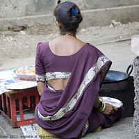 Buy canvas prints of Indian lady in purple traditional dress cooks poori in hot oil on the street by Gordon Dixon