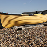 Buy canvas prints of Yellow fishing boat on shingle  - Brighton beach by Gordon Dixon