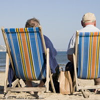 Buy canvas prints of Elderly couple in bright striped deckchairs on the sand at Weymouth by Gordon Dixon