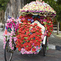 Buy canvas prints of Eccentric floral decorations on pedal powered trishaw - Melaka. Malaysia by Gordon Dixon