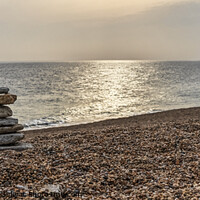 Buy canvas prints of Tranquil beach with stone sculpture and sun on water - Dorset by Gordon Dixon