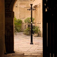 Buy canvas prints of Looking into the Hospital of St John the Baptist through an Arch Gate by Rowena Ko