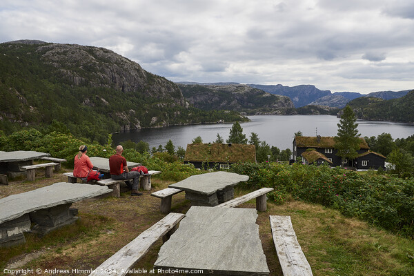 A couple relaxes at Preikestolen Base Camp with a view of Lake R Picture Board by Andreas Himmler
